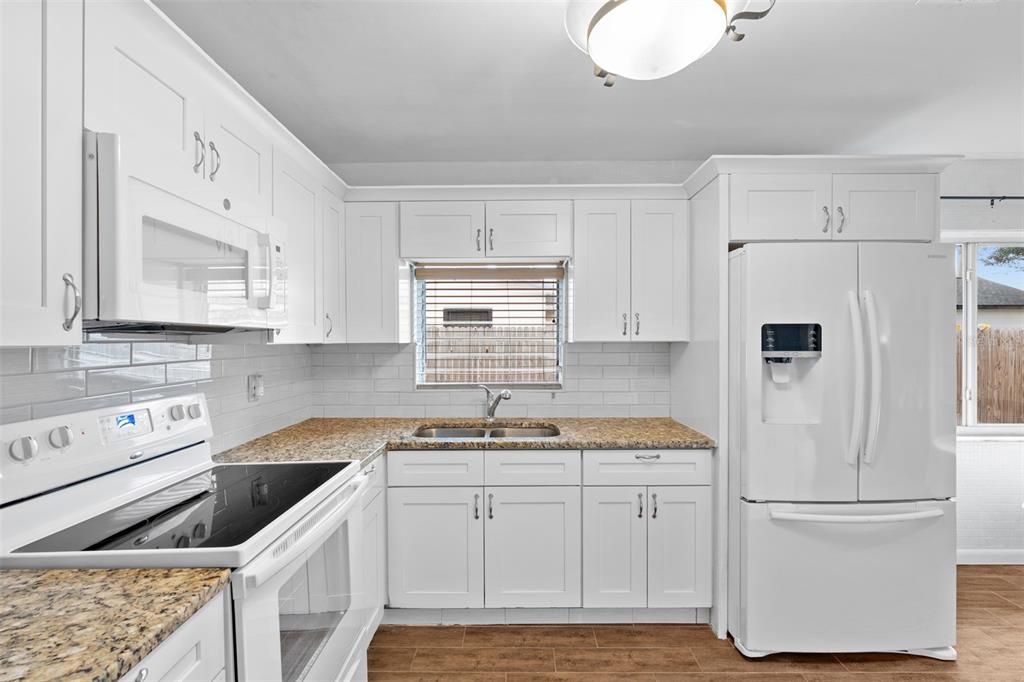 755 43rd Street St. Petersburg, FL 33713 - Photo 11 of 46 a kitchen with white cabinets and white appliances