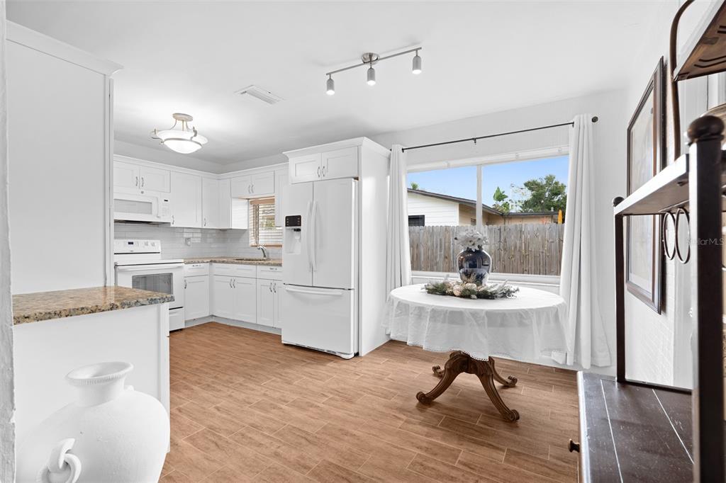 755 43rd Street St. Petersburg, FL 33713 - Photo 8 of 46 a kitchen with white cabinets and stainless steel appliances