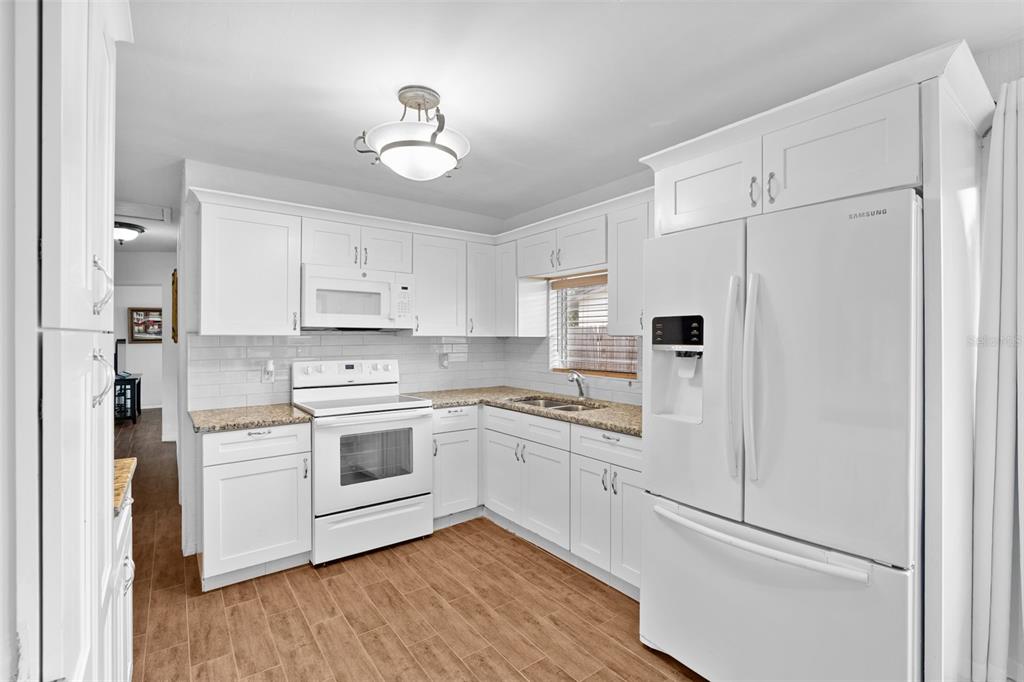 755 43rd Street St. Petersburg, FL 33713 - Photo 10 of 46 a kitchen with white cabinets and white appliances