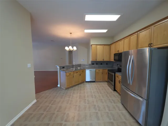a large kitchen with a large counter top cabinets and stainless steel appliances