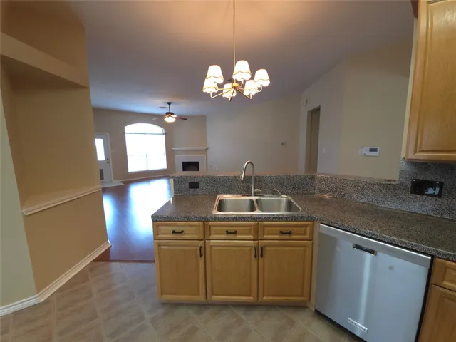 a kitchen with cabinets and chandelier