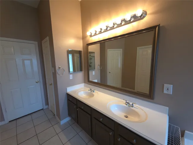 a bathroom with a double vanity sink and a mirror