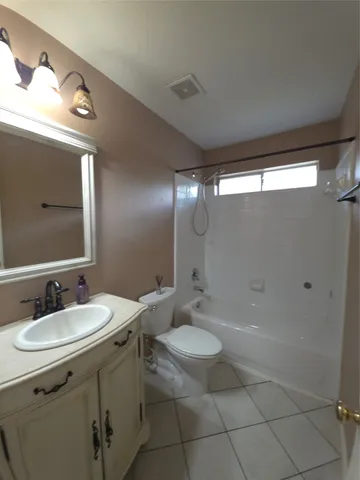 a bathroom with a sink a toilet a mirror and shower