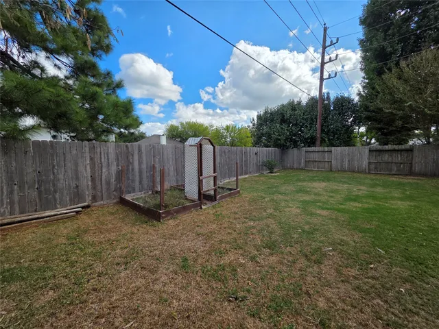 a view of a backyard with a fence and plants