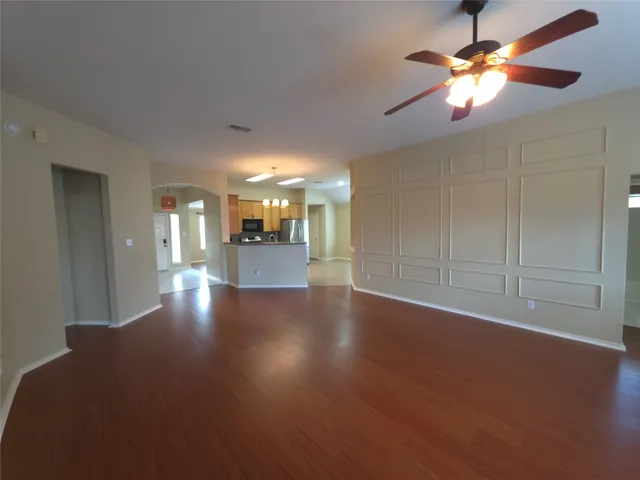 a view of a livingroom with a kitchen stove wooden cabinets and a fireplace