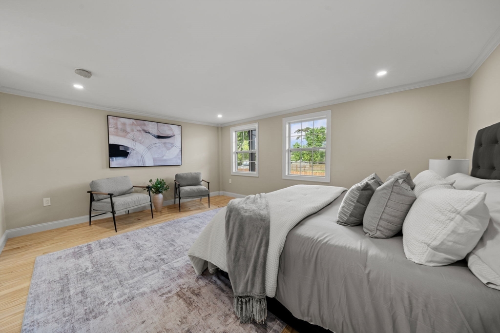 162 High Street, Unit B Danvers, MA 01923 - Photo 16 of 32 a bedroom with a bed and a chandelier