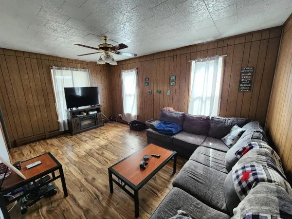 a living room with furniture a flat screen tv and a window
