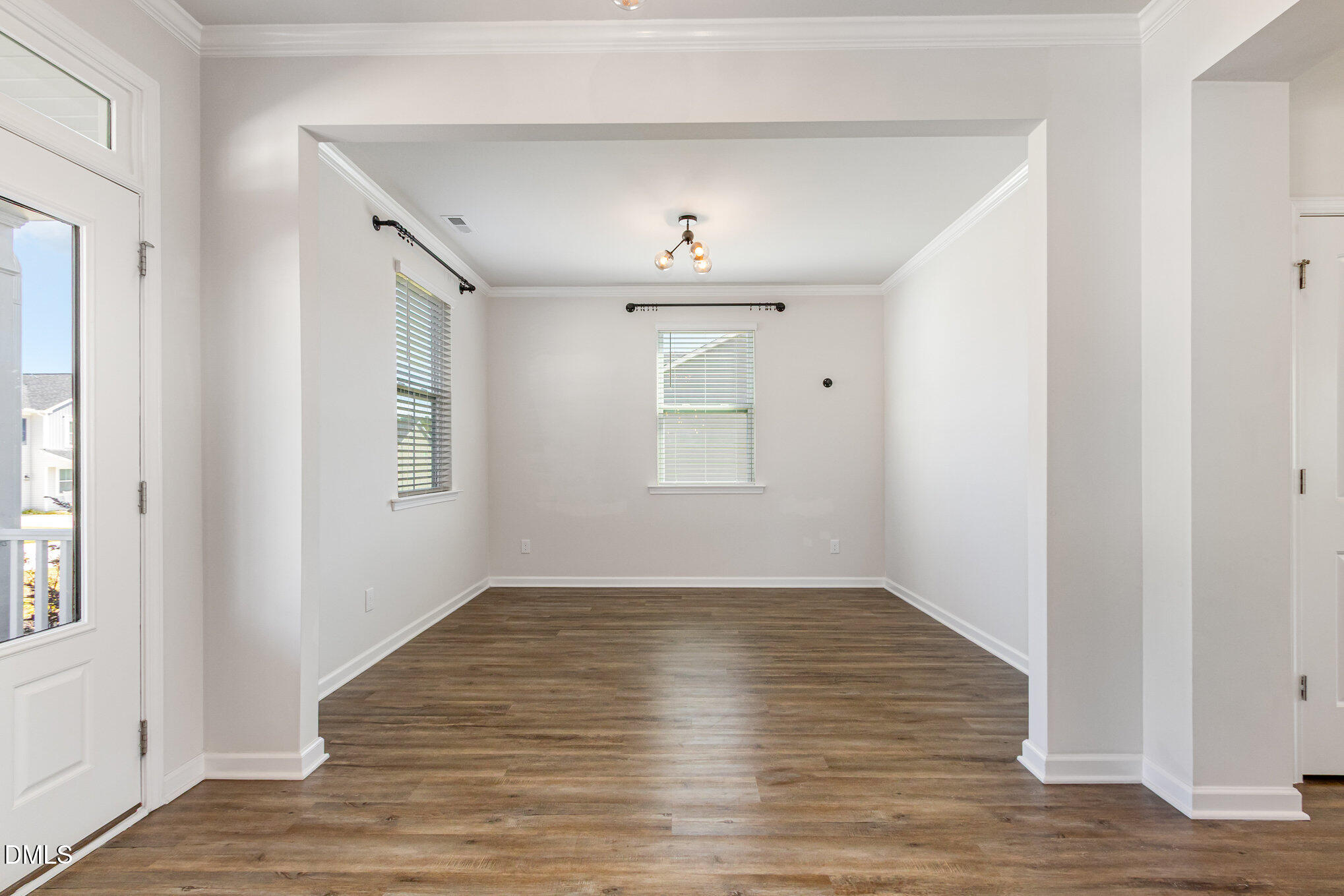 39 Calabor Court Fuquay-Varina, NC 27526 - Photo 32 of 40 an empty room with wooden floor chandelier and windows
