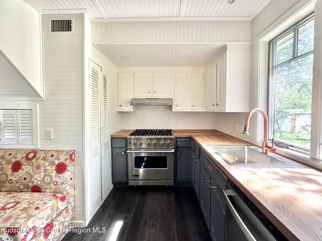 a kitchen with granite countertop a sink stove and cabinets