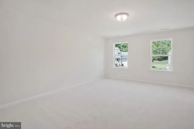 an empty room with closet and windows