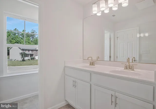 a bathroom with double sink and a mirror