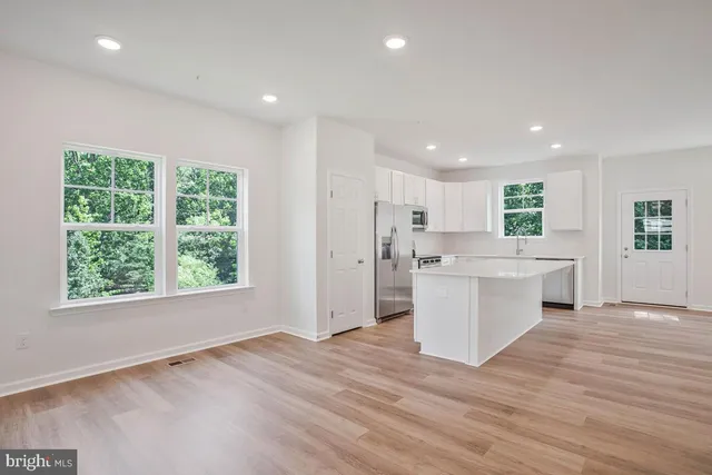 a view of a kitchen with wooden floor and electronic appliances