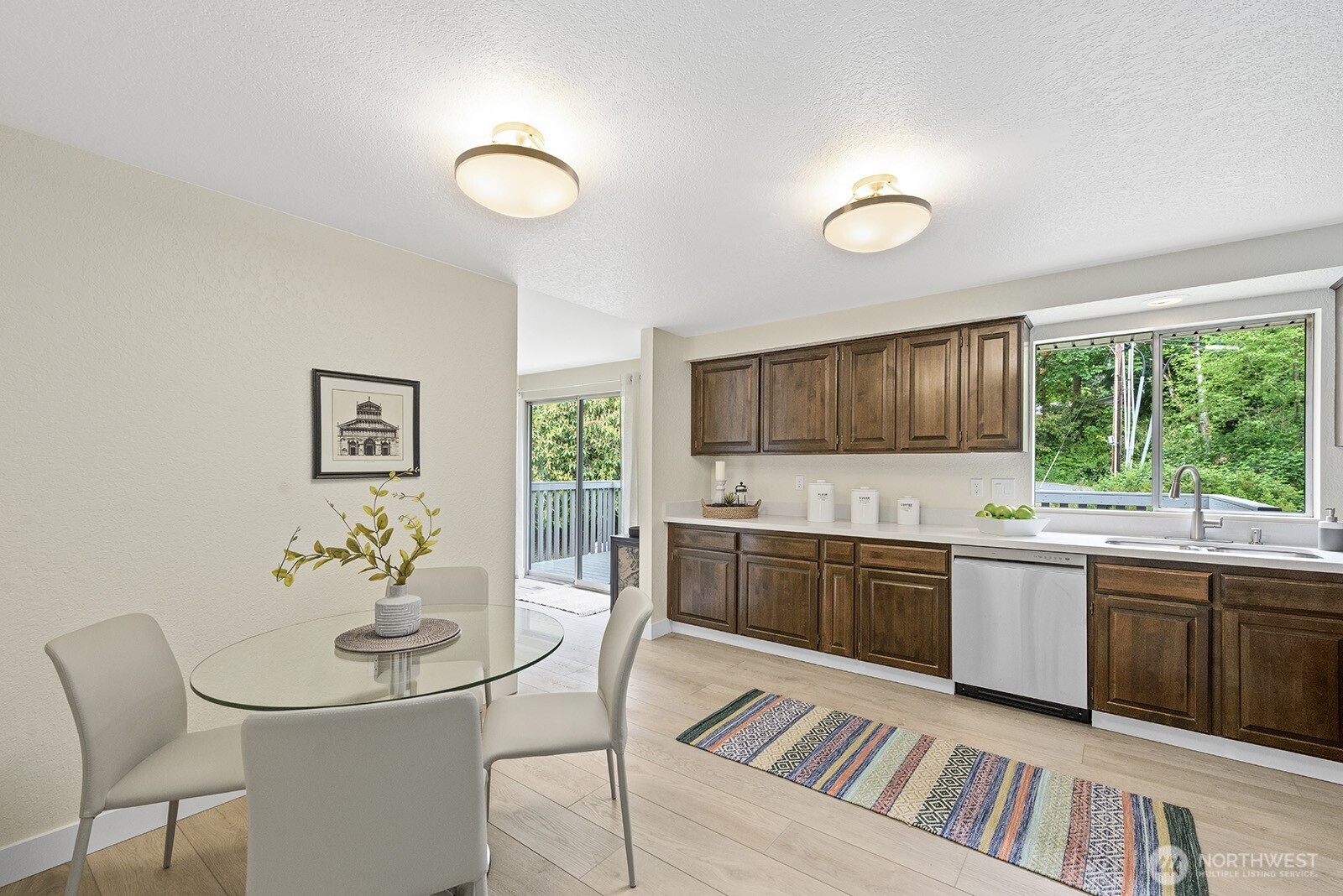 22032 3rd Place West Bothell, WA 98021 - Photo 7 of 20 a kitchen with a stove a sink a kitchen island with chairs and wooden floor