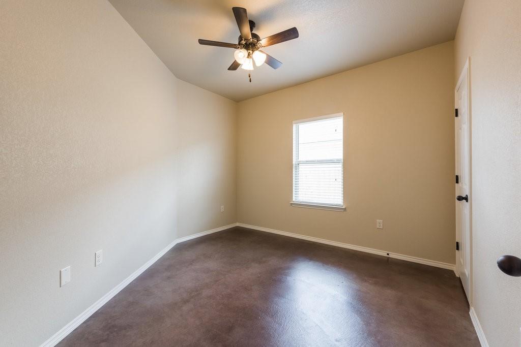 491 Jack Rabbit Lane, Unit A Buda, TX 78610 - Photo 16 of 22 An airy bedroom with a ceiling fan and a window for natural light.