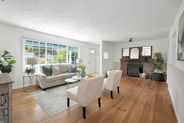 a living room with furniture a fireplace a potted plant and a window