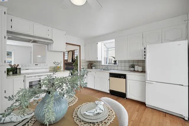 a kitchen with a refrigerator and white cabinets