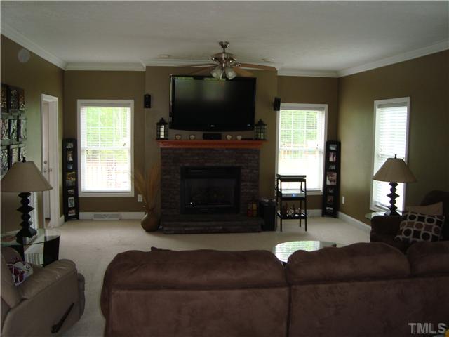 906 Oak Grove Mount Zion Road Roxboro, NC 27574 - Photo 2 of 11 a living room with furniture a fireplace and a flat screen tv