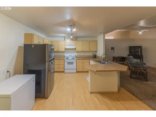 a kitchen with stainless steel appliances granite countertop a sink a stove top oven a counter space and cabinets