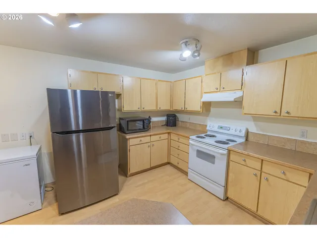 a kitchen with a sink dishwasher and a fireplace with wooden floor