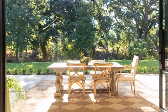 a view of a patio with table and chairs with wooden fence and floor