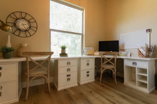 a living room with couches a flat screen tv and windows