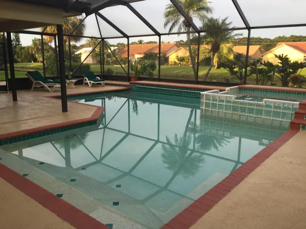 a view of a swimming pool with a patio and a yard
