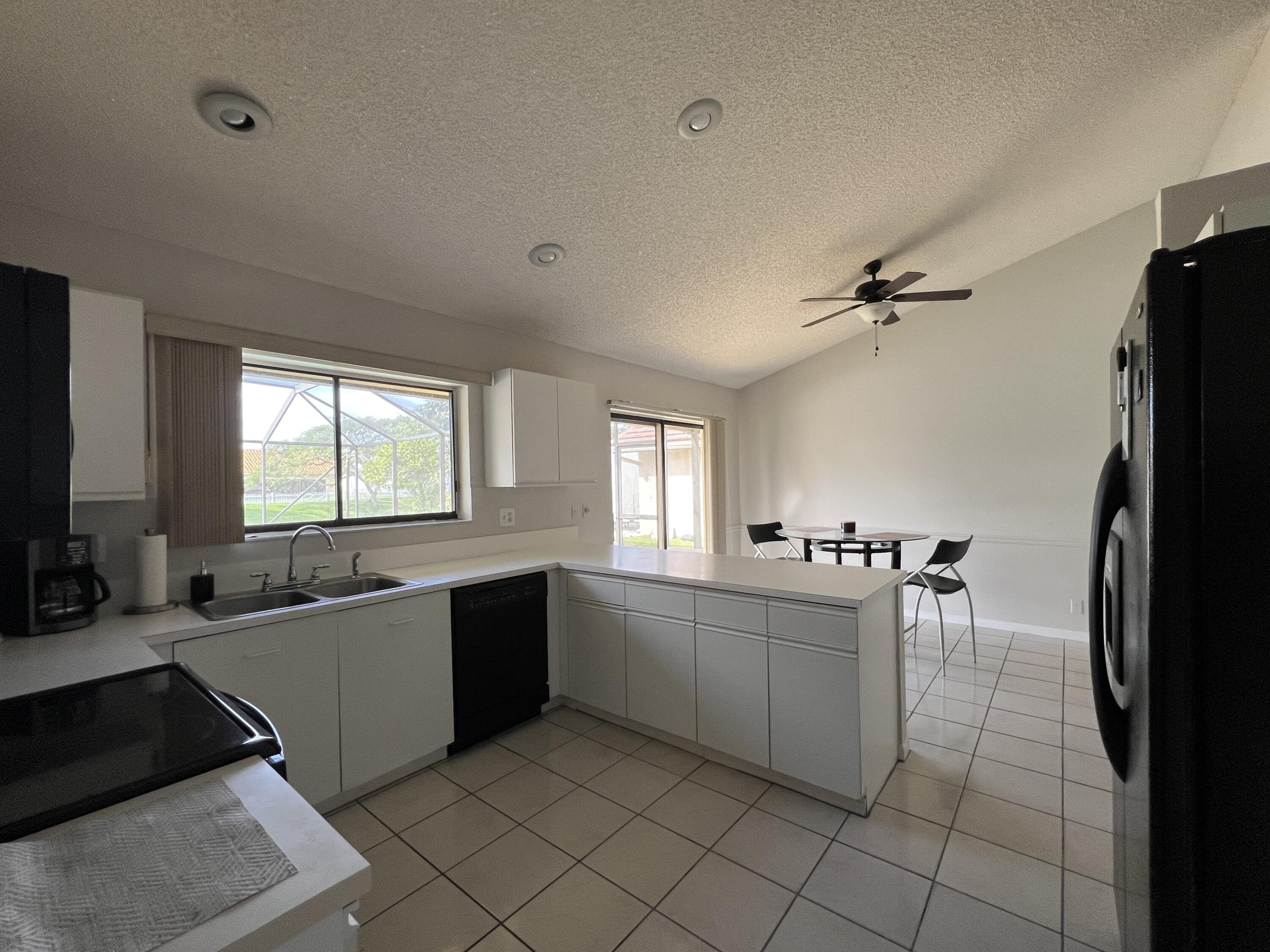 9775 Sun Pointe Drive Boynton Beach, FL 33437 - Photo 5 of 30 a large white kitchen with a large window