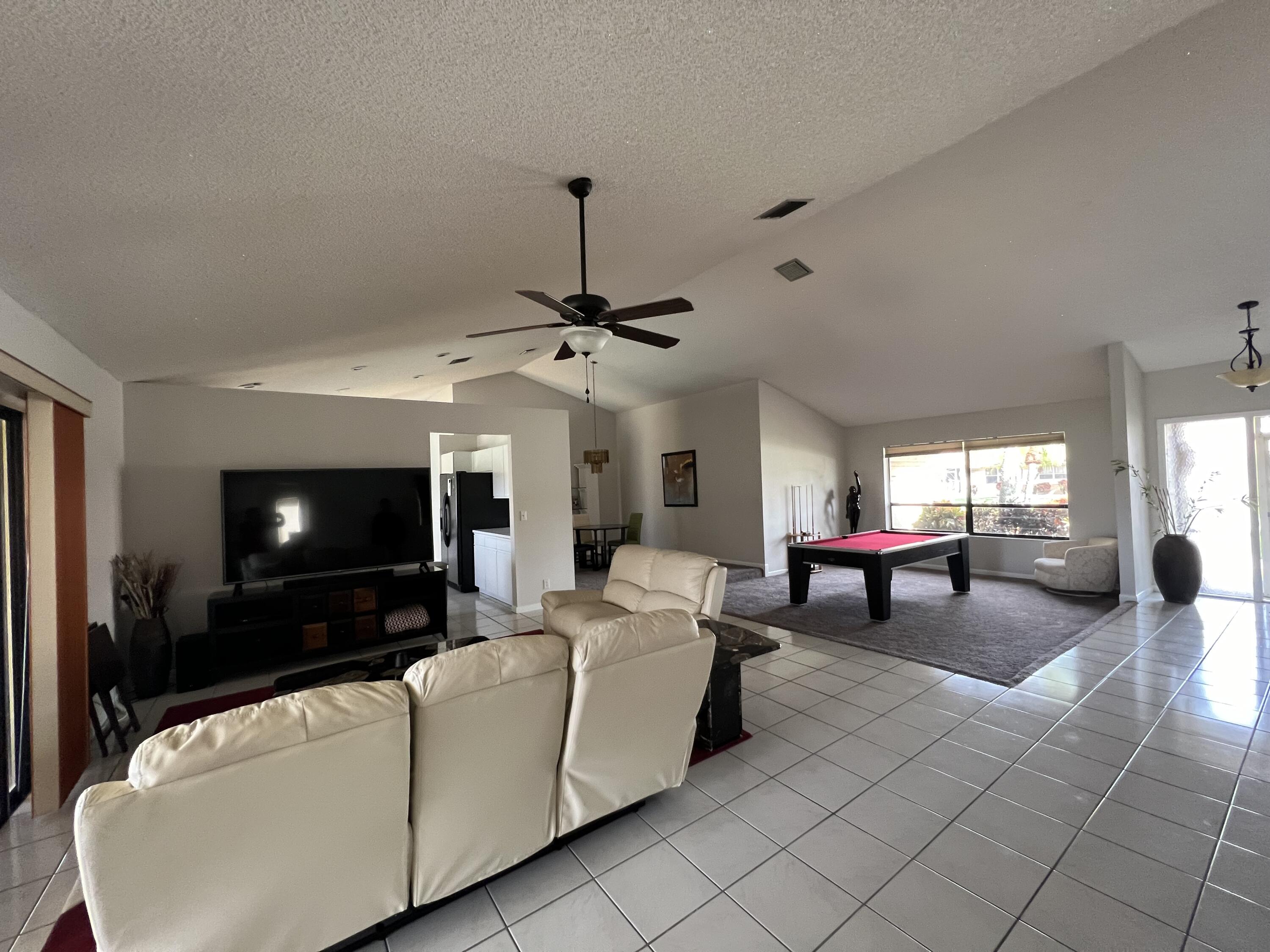 9775 Sun Pointe Drive Boynton Beach, FL 33437 - Photo 7 of 30 a living room with furniture and a flat screen tv
