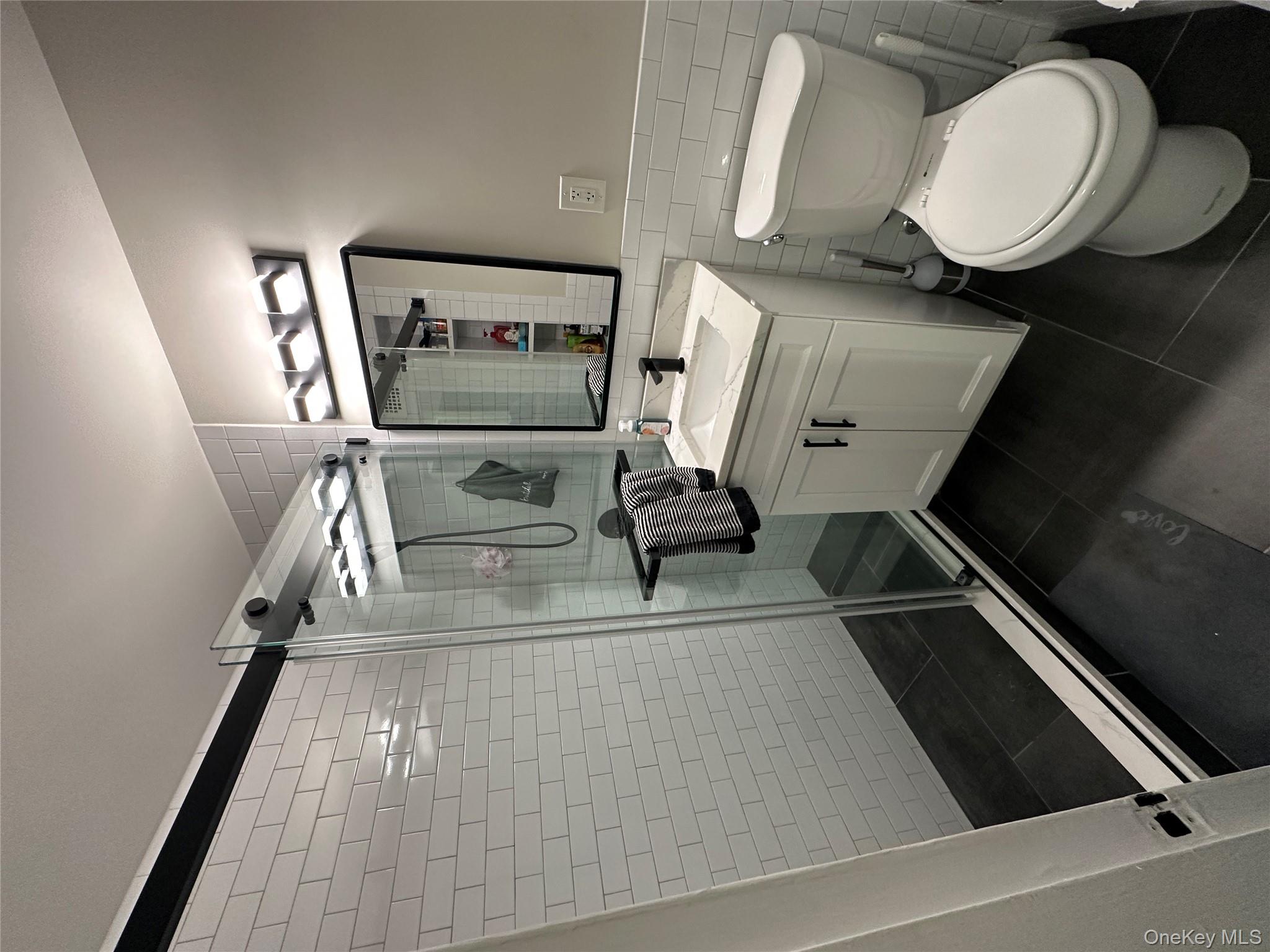 241-20 Northern Boulevard, Unit 1M Queens, NY 11362 - Photo 13 of 31 a bathroom with a sink toilet and shower