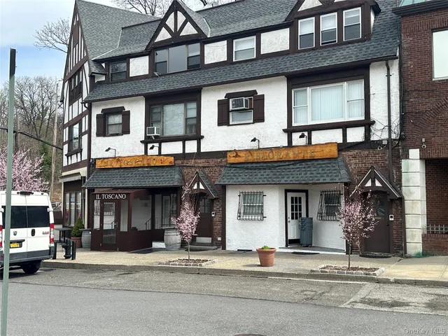 a front view of a building and car parked