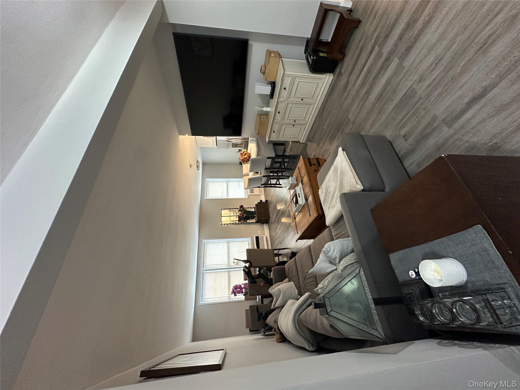 241-20 Northern Boulevard, Unit 1M Queens, NY 11362 - Photo 6 of 31 a living room with furniture and a flat screen tv