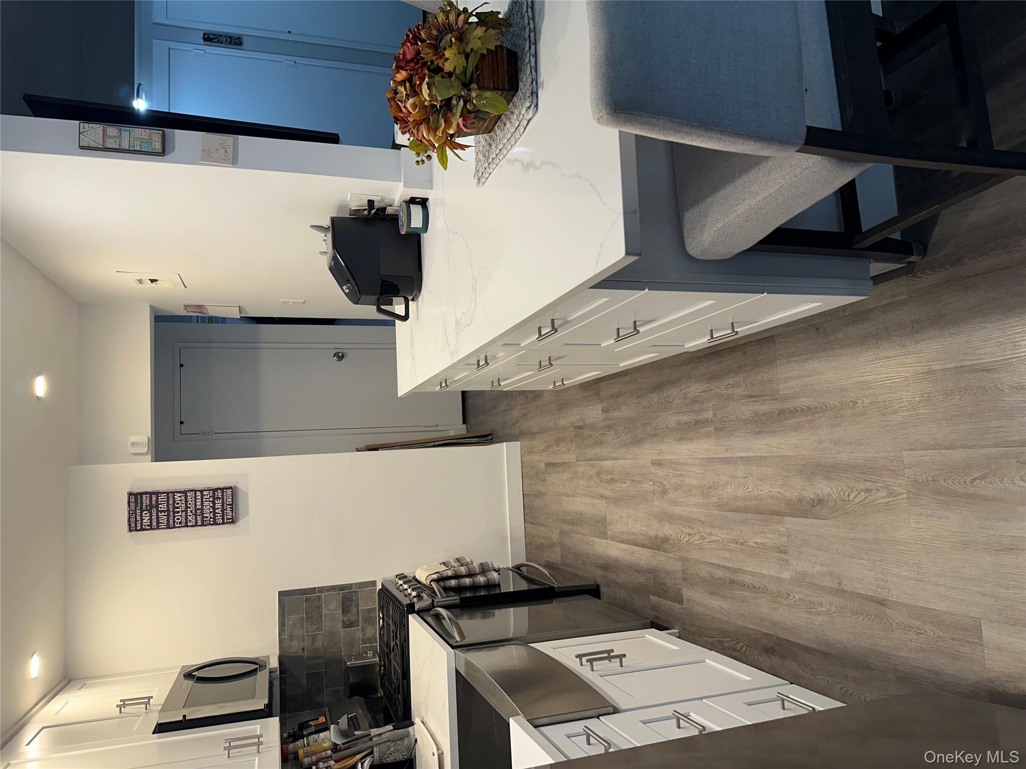 241-20 Northern Boulevard, Unit 1M Queens, NY 11362 - Photo 7 of 31 a kitchen with a sink a stove and chairs