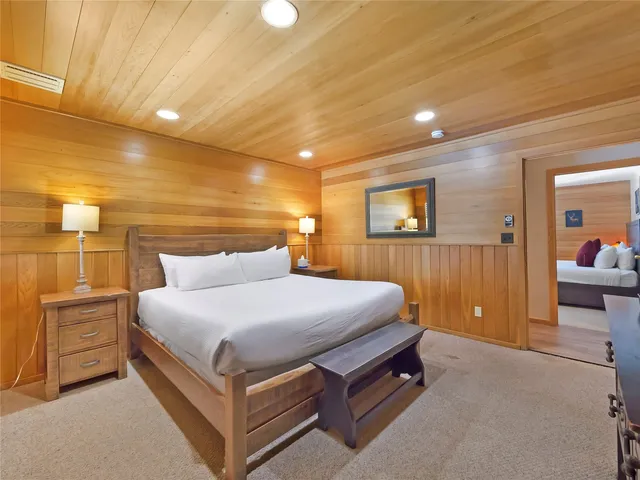 a bedroom with a bed and a lamp with the bathroom