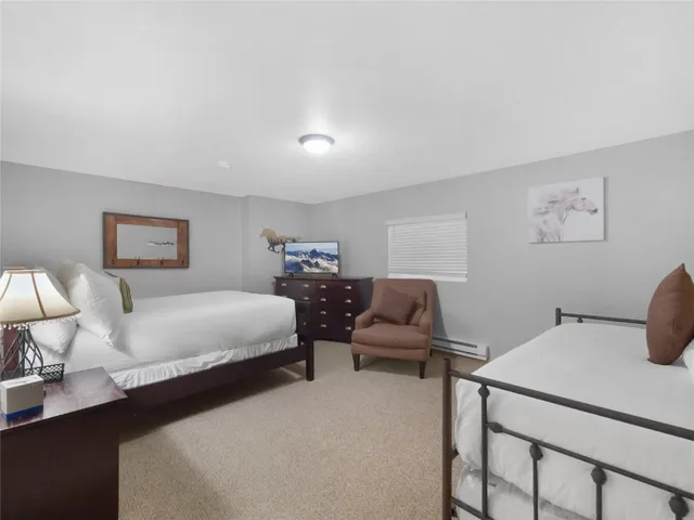 a bedroom with two beds and lamp