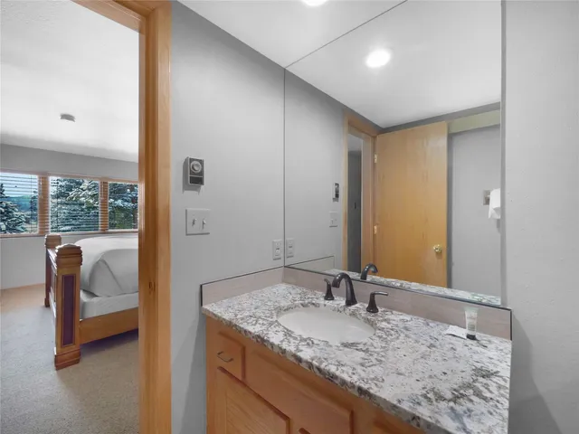 a bathroom with a granite countertop sink and a mirror