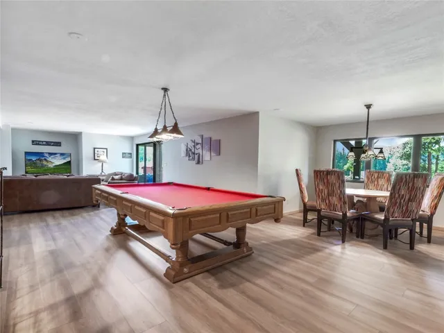 a living room with a table chairs and a wooden floor