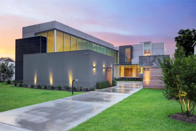 a view of a house with a yard and a large tree