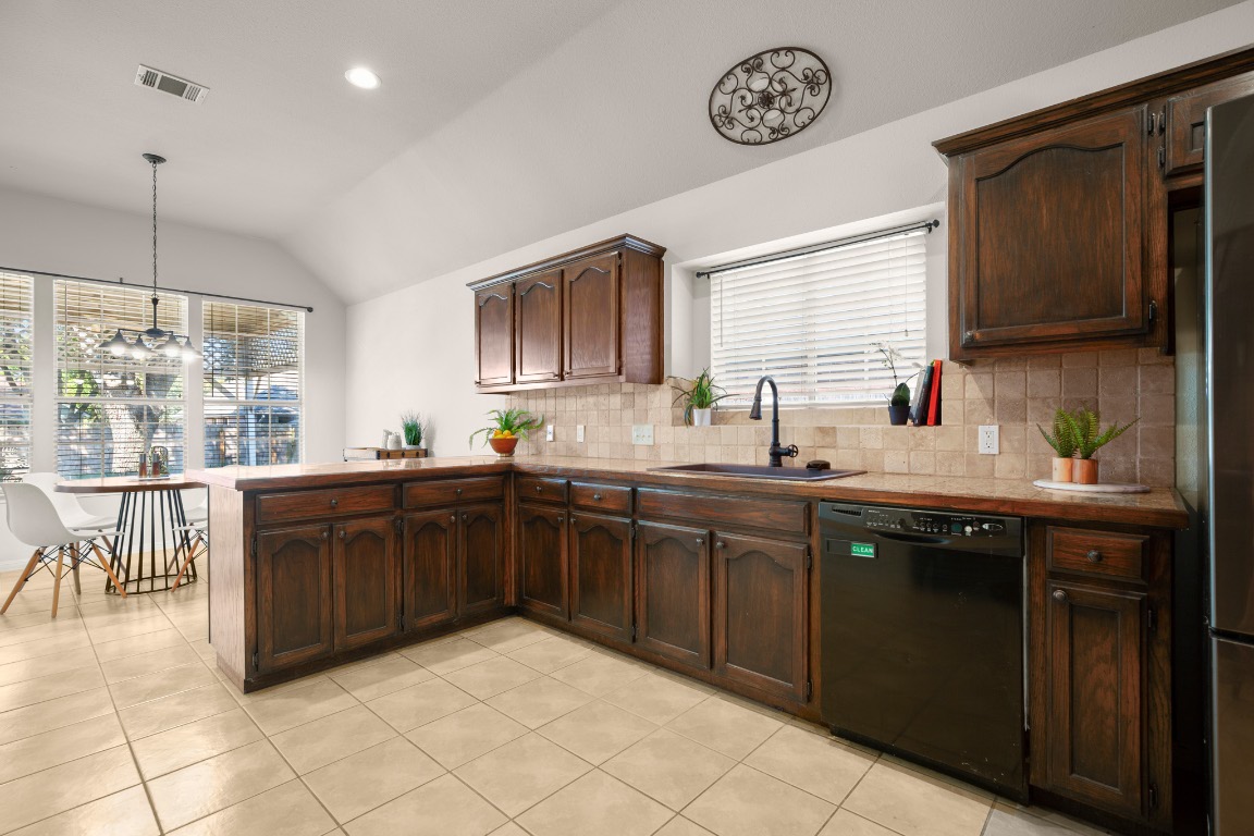 1206 Brophy Drive Pflugerville, TX 78660 - Photo 17 of 29 a kitchen with stainless steel appliances granite countertop a sink and cabinets