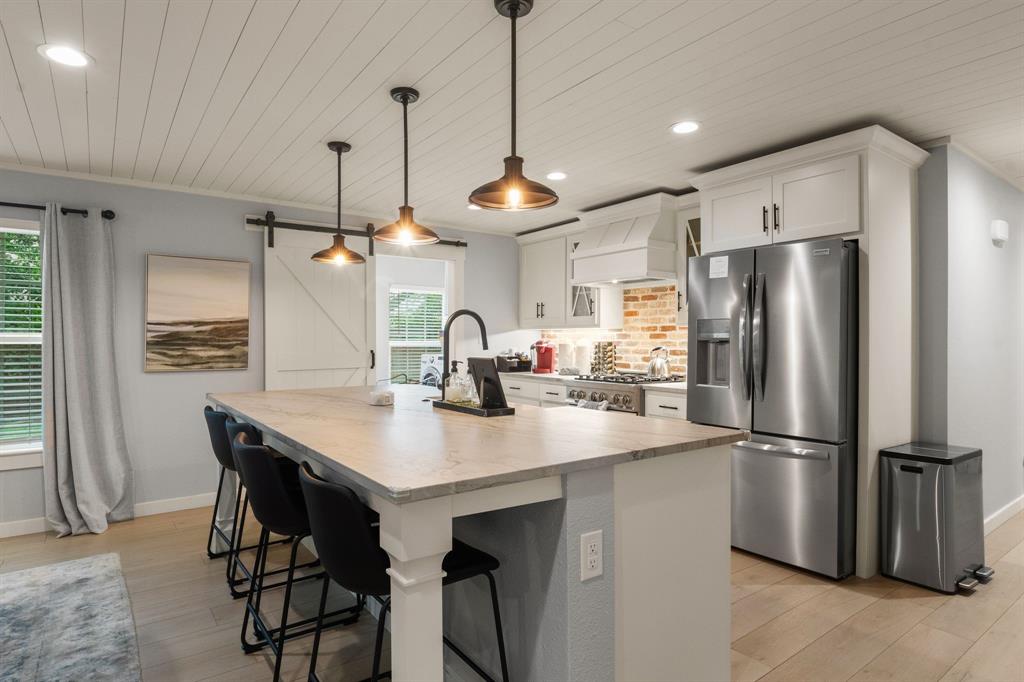 408 East Liberty Street Pilot Point, TX 76258 - Photo 16 of 31 a kitchen with stainless steel appliances a refrigerator a sink a stove a dining table and chairs