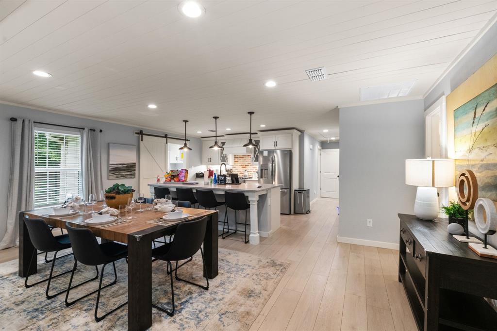 408 East Liberty Street Pilot Point, TX 76258 - Photo 5 of 31 a kitchen with stainless steel appliances kitchen island granite countertop a table chairs and a refrigerator