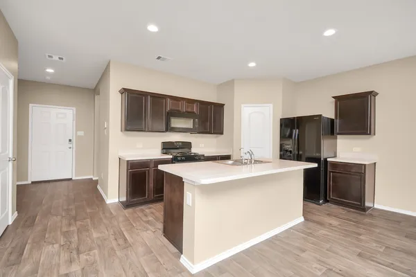 a kitchen with stainless steel appliances a stove top oven a refrigerator a sink and a refrigerator
