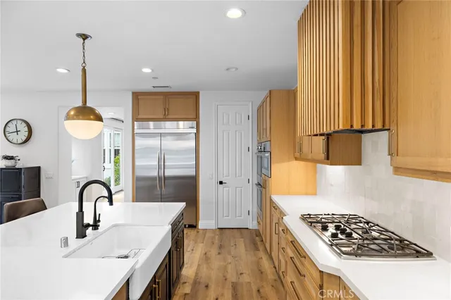 a living room with stainless steel appliances kitchen island granite countertop furniture and a wooden floor