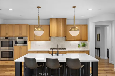 a kitchen with sink a refrigerator and chairs