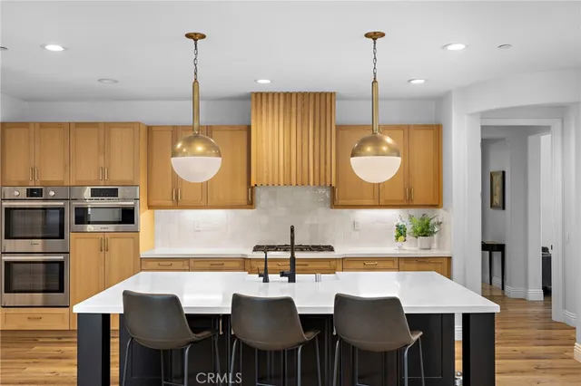 a kitchen with sink a refrigerator and chairs