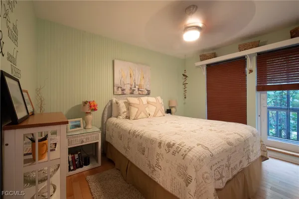 a bedroom with a bed and a flat tv screen on a dresser