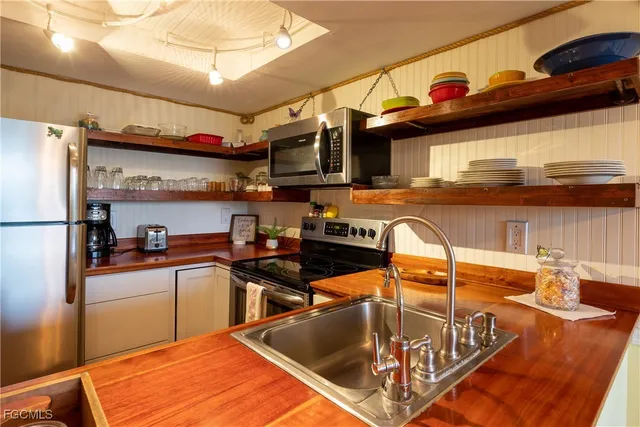 a kitchen with stainless steel appliances granite countertop a sink a stove and a refrigerator