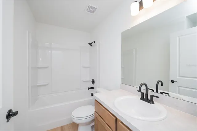 a bathroom with a bathtub shower sink mirror vanity and toilet