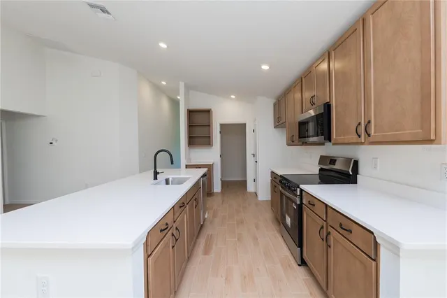 a kitchen with stainless steel appliances a sink stove top oven and cabinets