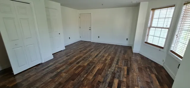 a view of a room with wooden floor and window