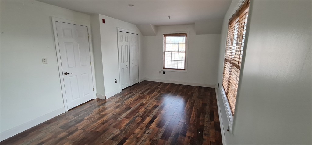 41 West Street, Unit 3 Boston, MA 02136 - Photo 13 of 23 a view of an empty room with wooden floor and a window
